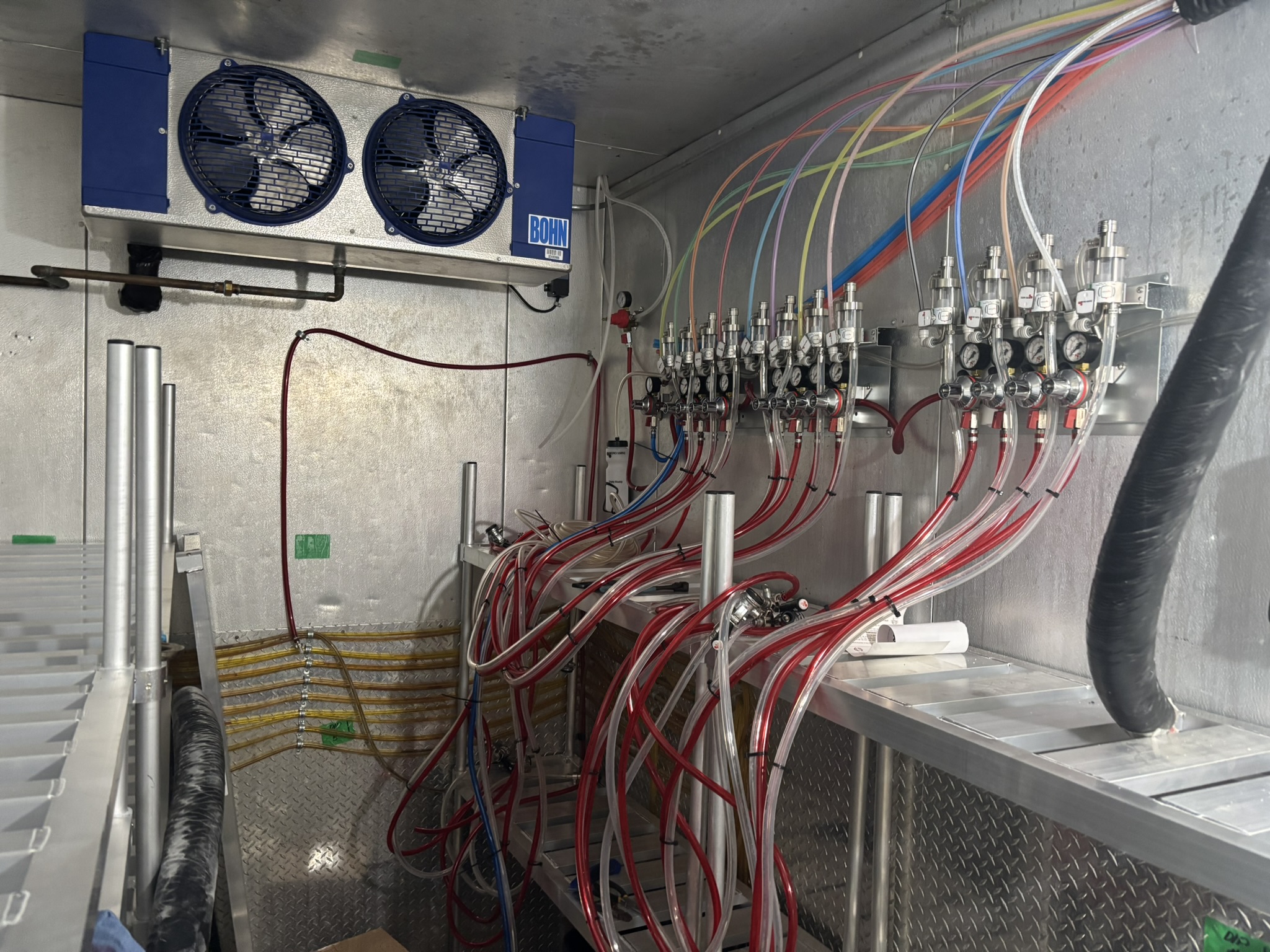 Large commercial regulator bank and product lines inside a walk-in cooler